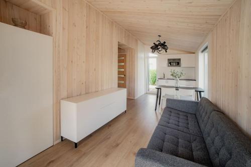 uma sala de estar com um sofá e uma mesa em EPA Brīvdienu mājiņa em Carnikava