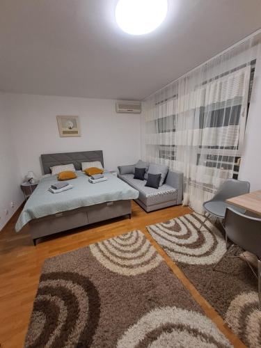 a bedroom with a bed and a couch at Manhattan studio Seboj Belvil in Novi Beograd
