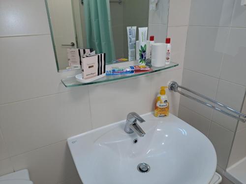 a white bathroom with a sink and a mirror at Manhattan studio Seboj Belvil in Novi Beograd