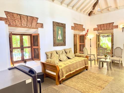 a bedroom with a bed in a room with windows at Casa Da Praia in Candolim