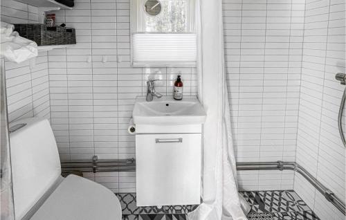 a white bathroom with a sink and a toilet at Nice Home In Strmstad With Wifi And 3 Bedrooms in Strömstad