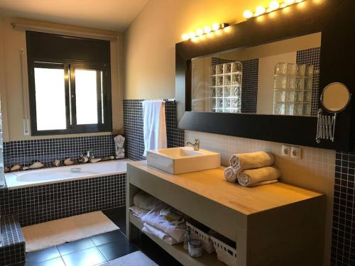 a bathroom with a sink and a tub and a mirror at Villa con piscina privada in Olivella