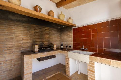 a kitchen with a brick wall and a counter at Villa Jaume in Pollença