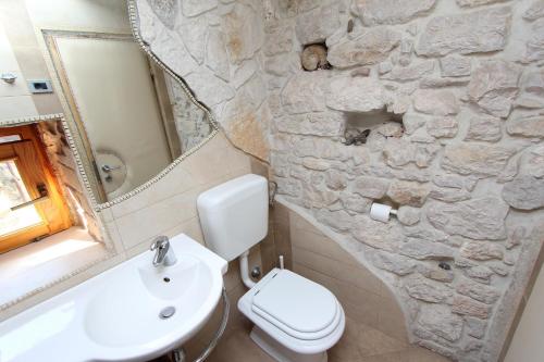Apartment Midea في روفينج: حمام به مرحاض أبيض ومغسلة