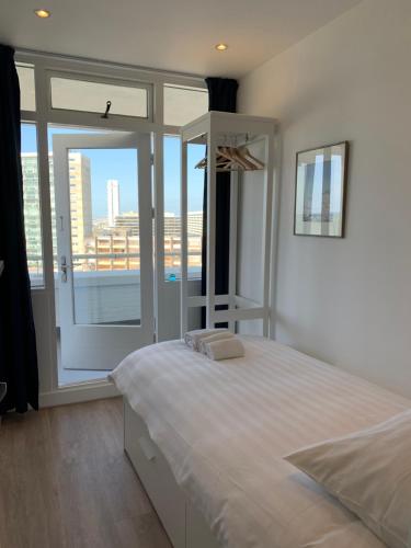 ein Schlafzimmer mit einem großen Bett und einem großen Fenster in der Unterkunft North Sea Spirit in Zandvoort