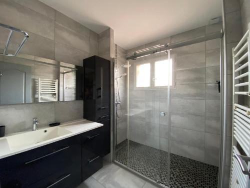 a bathroom with a glass shower and a sink at Villa Triskyl in Le Muy