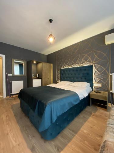 sypialnia z dużym łóżkiem z niebieską narzutą w obiekcie EVİM APART HOTEL w mieście Termal