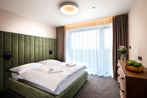 1 dormitorio con cama grande y ventana grande en Royal Village - Royal Views apartments, en Malý Slavkov