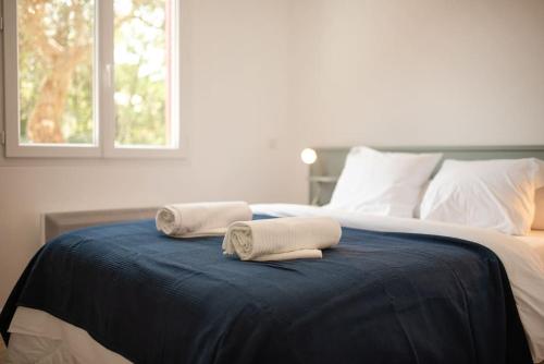 two towels sitting on top of a bed at Villa Cat'Cha Ti Binta in Ondres