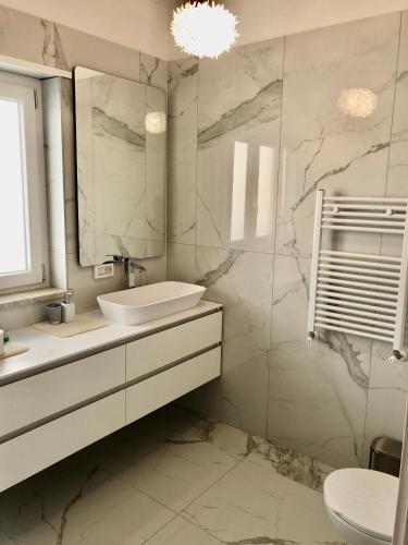 a white bathroom with a sink and a mirror at Tropea Hills #5 in Santa Domenica