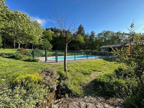 une piscine avec un arbre dans une cour dans l'établissement Maison indépendante avec piscine, à Jaujac