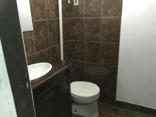 a bathroom with a toilet and a sink at Panambi in Asuncion