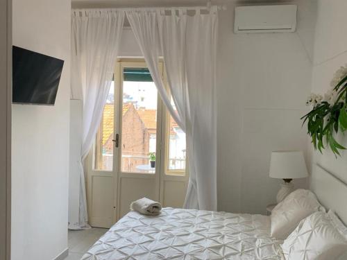 a white bedroom with a bed and a window at Maison Floria Locazione Turistica in Pescara