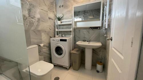 een badkamer met een wastafel en een wasmachine bij Seaview Apartment Mira Andalus in Sitio de Calahonda
