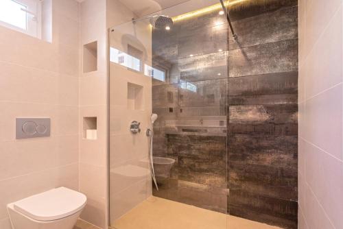 a bathroom with a toilet and a glass shower at Malagueta Luz by Renthas in Málaga