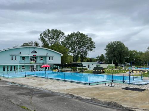 a building with a swimming pool in front of it at Rose Cottage in Prievidza