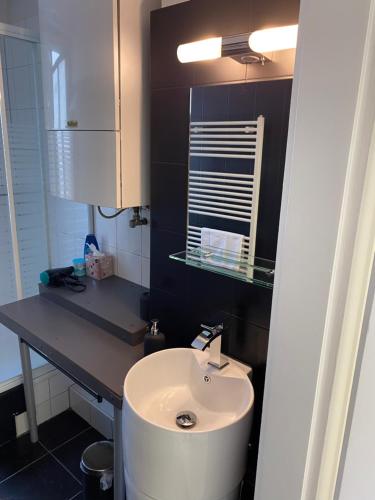 uma casa de banho com um lavatório branco e um espelho. em 3 Zimmer City Apartment, TV, Netflix, WLAN, Free Parking em Bielefeld
