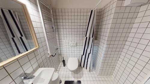 een wit betegelde badkamer met een toilet en een wastafel bij IN Budapest Apartment 2 in Boedapest