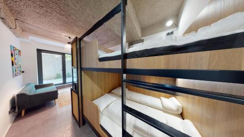 een kamer met 2 stapelbedden en een stoel bij IN Budapest Apartment 2 in Boedapest