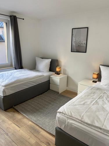 a bedroom with two beds and two tables with lamps at 3 Zimmer City Apartment, TV, Netflix, WLAN, Free Parking in Bielefeld