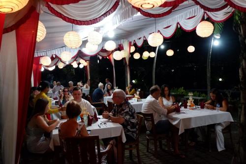 a group of people sitting at tables in a restaurant at Swastika Bungalows in Sanur