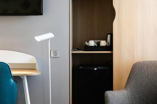 a room with a desk and a chair and a lamp at Holiday Inn Perpignan by IHG in Perpignan