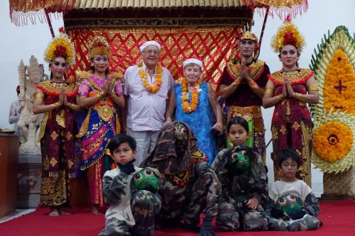 a family posing for a picture in front of a temple at Swastika Bungalows in Sanur