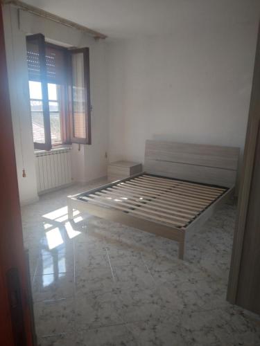 1 dormitorio con 1 cama en una habitación con 2 ventanas en Casa Costantino en Campanedda