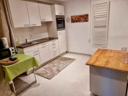 una cocina con armarios blancos y una mesa verde en Big Apartment with garden Rapperswil-Jona, en Jona