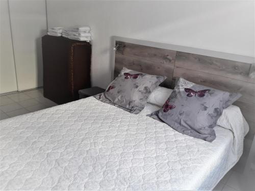 une chambre avec un lit blanc avec deux oreillers dans l'établissement Superbe Appartement FREJUS PLAGE, à Fréjus