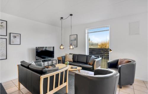 a living room with two couches and a table at Holiday Home Arvidvej Iv Denmark in Bjerregård