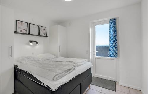 a white bedroom with a bed and a window at Amazing Home In Hvide Sande With Wifi in Bjerregård