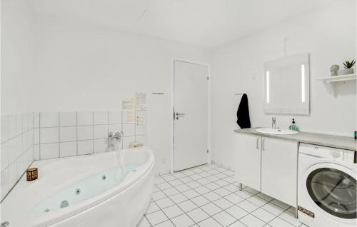 a white bathroom with a tub and a washing machine at Amazing Home In Hvide Sande With Wifi in Bjerregård