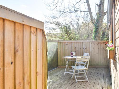 a patio with a table and chairs on a wooden deck at Milos View in Totnes