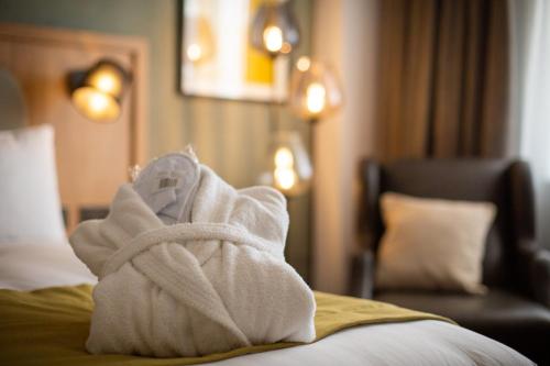 a pile of white towels sitting on top of a bed at Holiday Inn Oxford by IHG in Oxford
