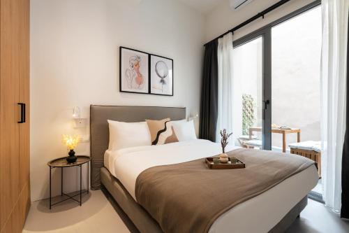 a bedroom with a large bed and a large window at Play Psyri Athens in Athens