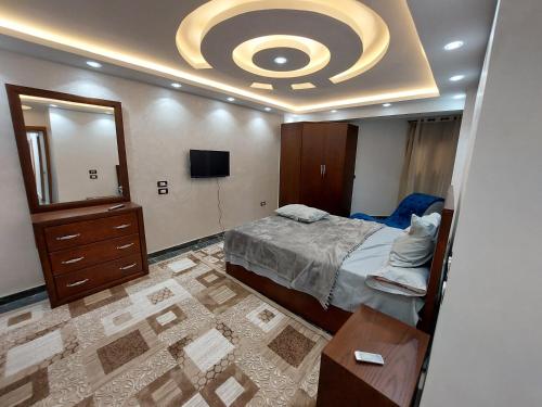 - une chambre avec un lit, une commode et un miroir dans l'établissement جامعة الدول العربية ميدان سفنكس, au Caire