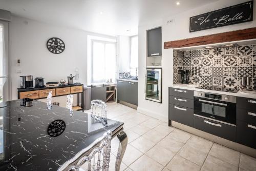 a kitchen with a black and white counter top at Gîte Chez Louis le Tonnelier Suite First in Le Mesnil-sur-Oger