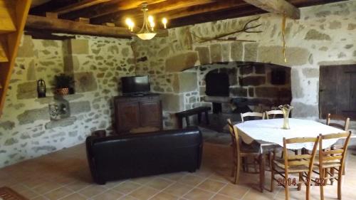 une salle à manger avec une table et une cheminée dans l'établissement Domaine de Nalou - Gîte, à Saint-Geniez-ô-Merle