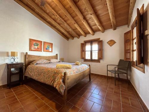 Un dormitorio con una cama y un techo de madera. en Campanario 3, en Alájar
