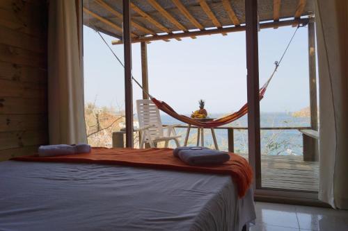 a bedroom with a hammock and a view of the water at Hotel Cactus Taganga in Taganga