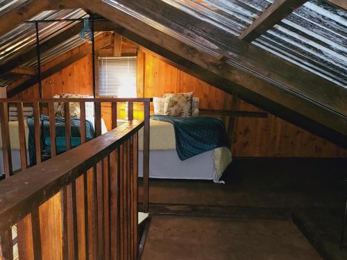 a bedroom in a wooden cabin with a bed at Rosenhof Loft Cabins in Clanwilliam
