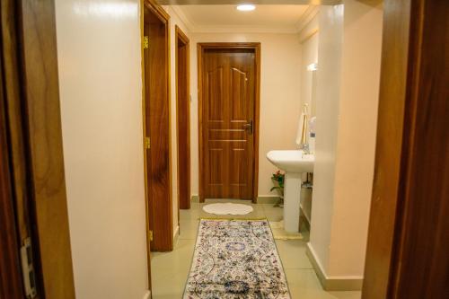 y baño con aseo y lavamanos con alfombra. en The Fancy Luxurious 3 bedroom apartment, en Nakuru
