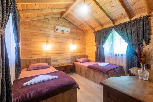 a room with two beds in a wooden cabin at Sheriff, Olympos in Kumluca