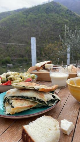einen Tisch mit Teller mit Brot und Käse in der Unterkunft Te baca Qerim in Lekbibaj