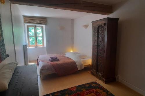 a bedroom with a bed and a dresser and a window at Charme Zen Ecrin de verdure Fraîcheur Spa en juillet in Pezens