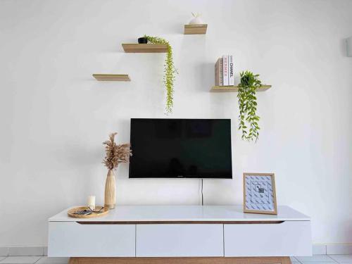 a white living room with a tv on a white wall at Muji Minimalist Homestay di Gambang in Kuantan