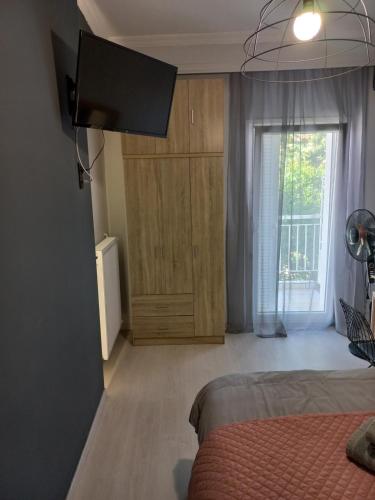 um quarto com uma cama, um armário e uma janela em Central 3 Modern Apartment with free parking em Serres