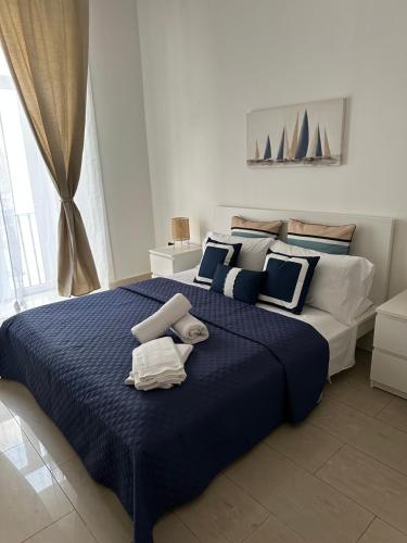 una camera da letto con un grande letto con lenzuola e cuscini blu di B&B mazzocchi a Santa Maria Capua Vetere