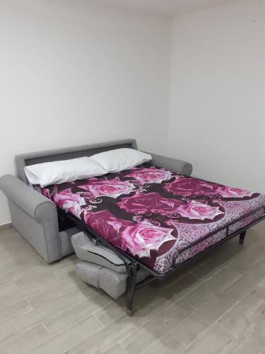 ein Bett mit einer lila Decke darüber in der Unterkunft House San Gennaro in Neapel
